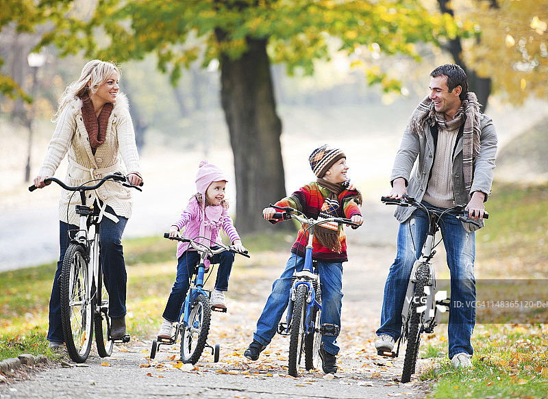 快乐家庭在大自然中骑自行车。图片素材