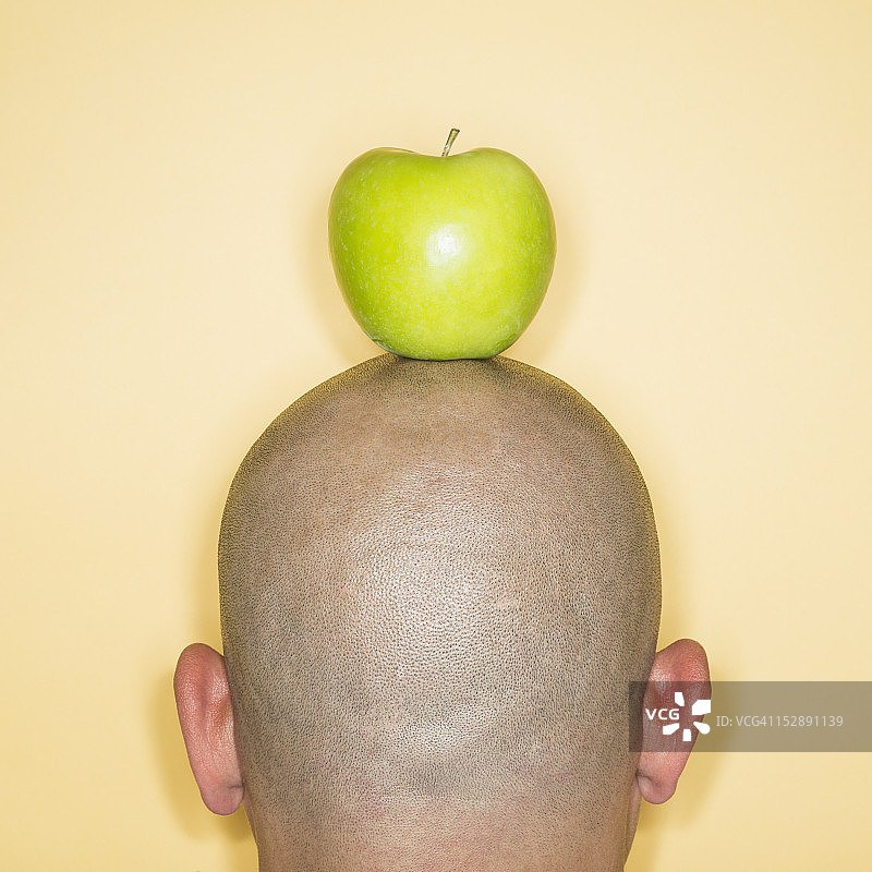 头上有苹果的人的后视图图片素材