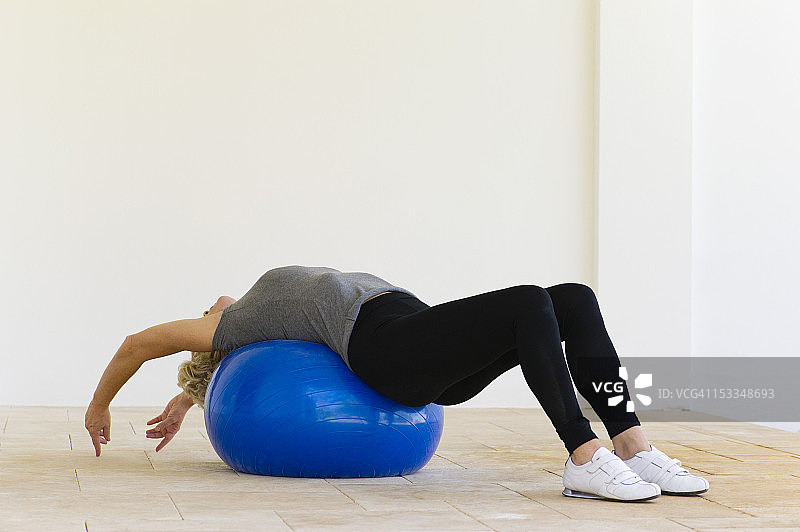 女人躺在健身球上伸展身体图片素材