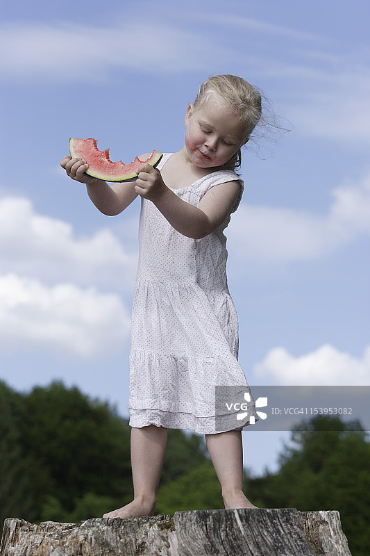 德国，巴伐利亚，女孩站着吃西瓜图片素材