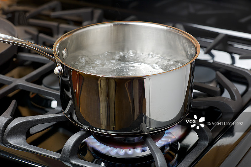 水在煤气炉上沸腾，不锈钢锅。图片素材