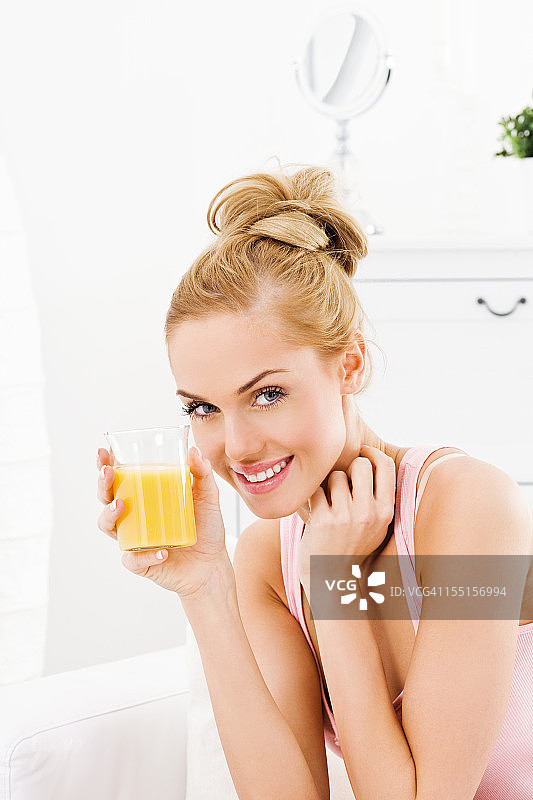 喝橙汁的年轻女子图片素材