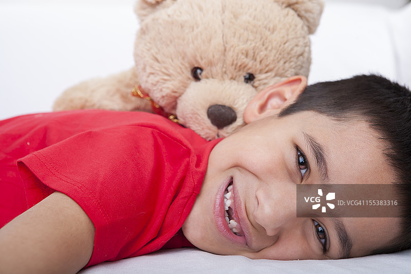 微笑的男孩与泰迪熊的关系图片素材