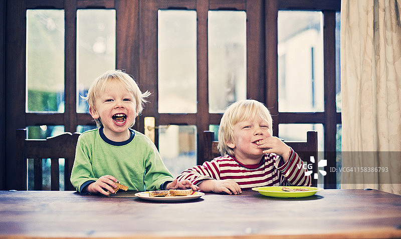 两个小男孩吃烤面包当早餐图片素材