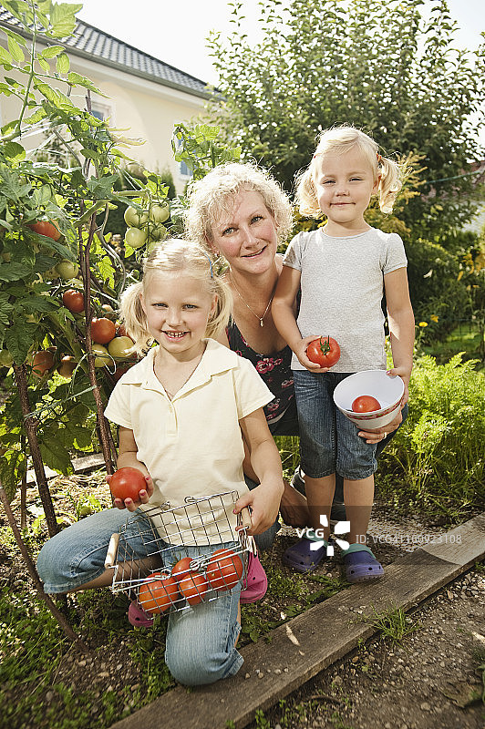 德国，巴伐利亚，奶奶和孩子们在菜园里图片素材