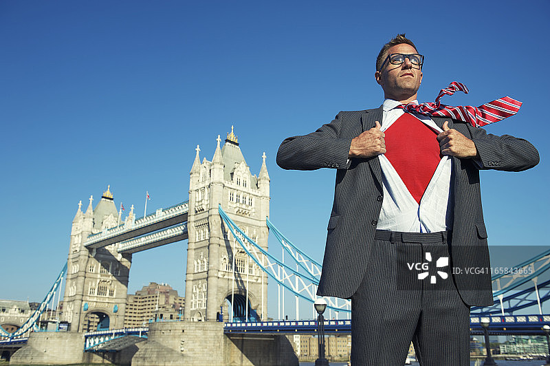 年轻的超级英雄商人在伦敦天际线展示红胸图片素材