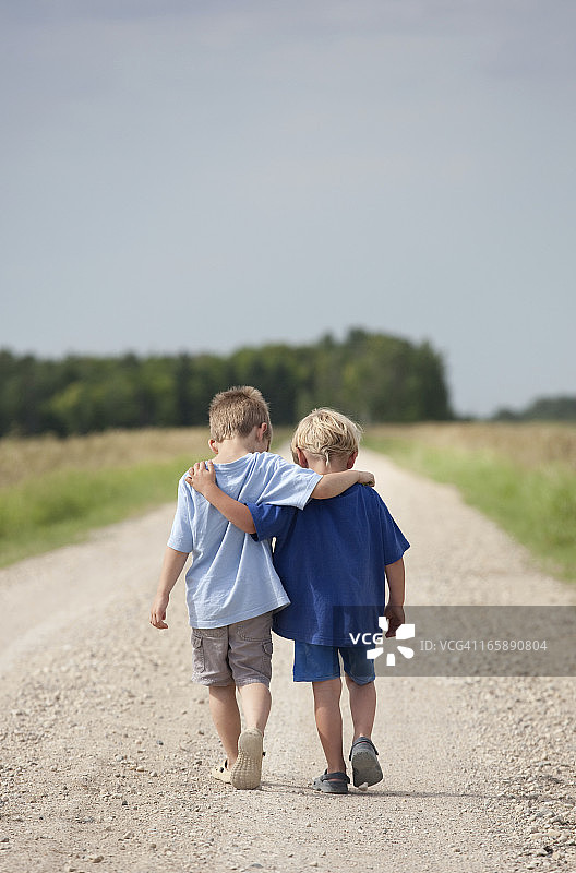 两个男孩走在砾石路上图片素材