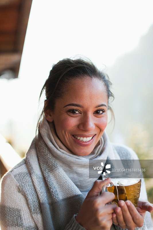 微笑的女人喝茶的肖像图片素材