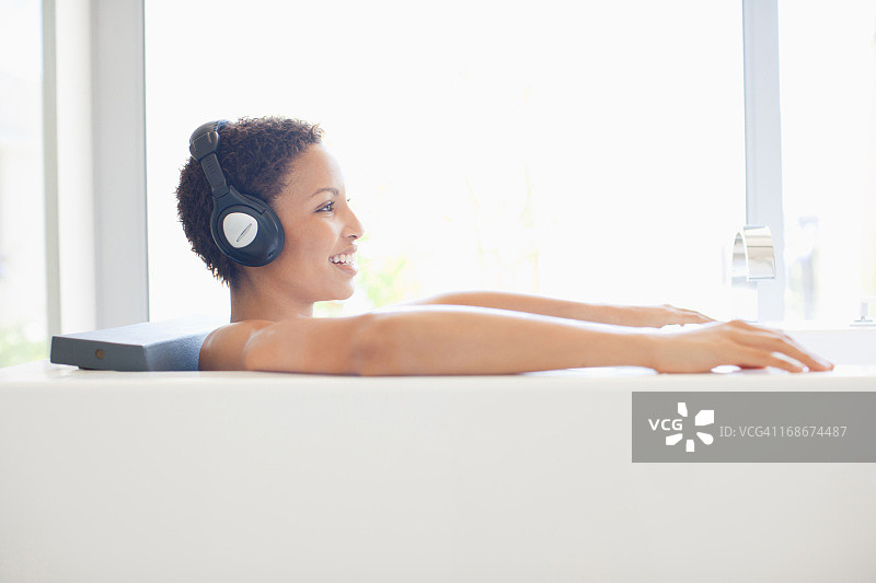 在浴缸里听音乐的女人图片素材