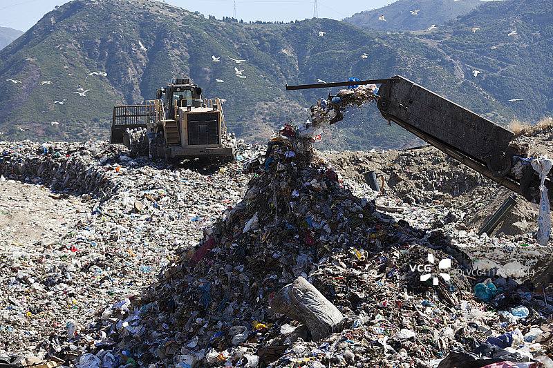 在垃圾填埋场倾倒垃圾的机器图片素材