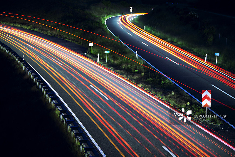夜间高速公路交叉处有车灯的痕迹图片素材