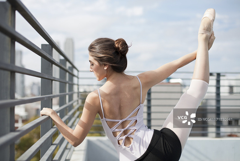 穿着尖头鞋的芭蕾舞女演员在阳光甲板上锻炼图片素材