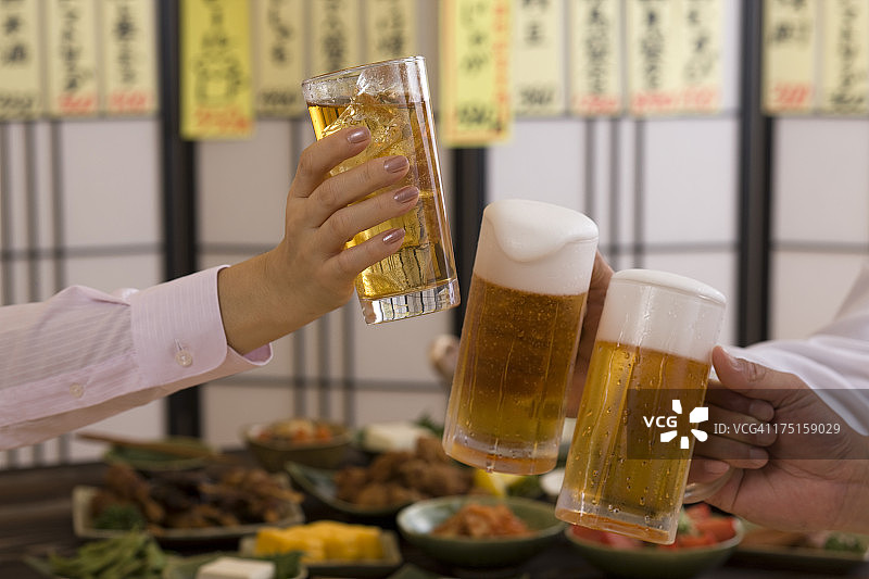 三个人在居酒屋用啤酒和Chu-Hi祝酒图片素材