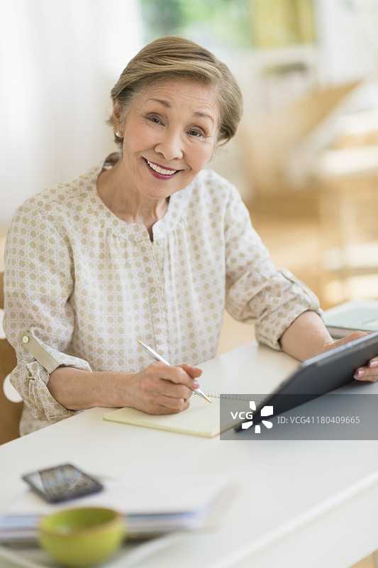 美国，新泽西州，泽西城，在家里使用平板电脑的老年妇女图片素材