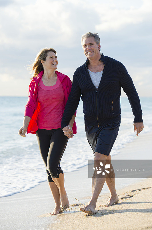一对白人夫妇在海滩上散步图片素材