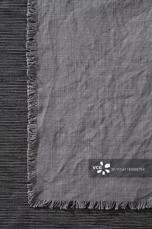 一块深灰色的餐巾放在桌布上图片素材