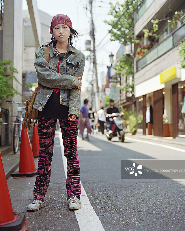 年轻女子站在城市的人行道上，肖像图片素材