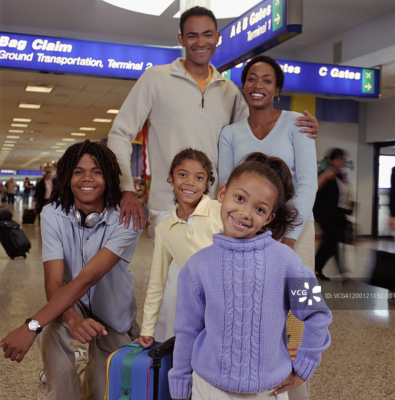 家人站在机场的行李领取处，肖像图片素材