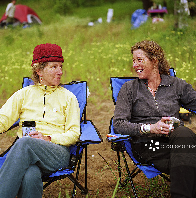 两个女人在野营椅上休息，互相看着对方图片素材