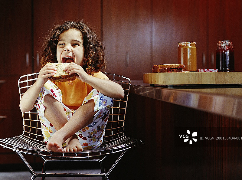 女孩(3-5)吃花生酱和果冻三明治图片素材