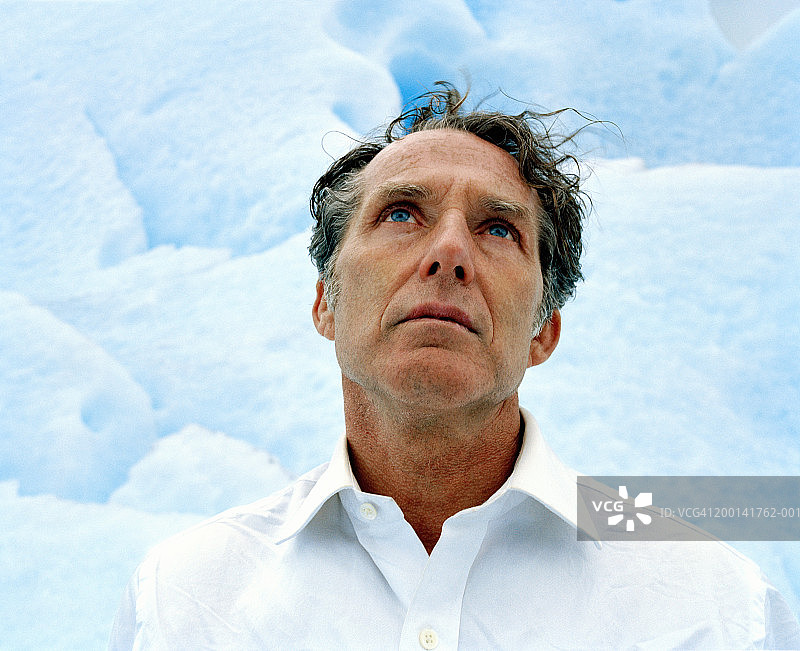 成熟的男人在冰川上向上看，近距离看图片素材