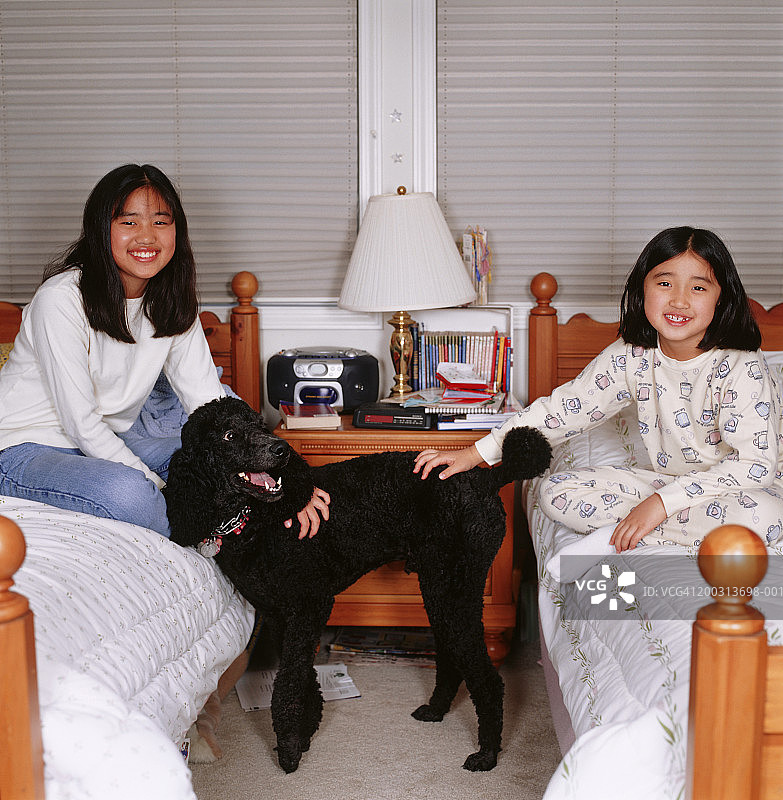 两姐妹(6-7)，(8-9)与狗，坐在卧室，肖像图片素材