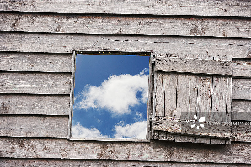 透过打开的天空和云彩的木制百叶窗观看图片素材