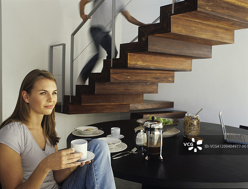 年轻女子坐着喝咖啡，男子跑上楼(神志不清)图片素材