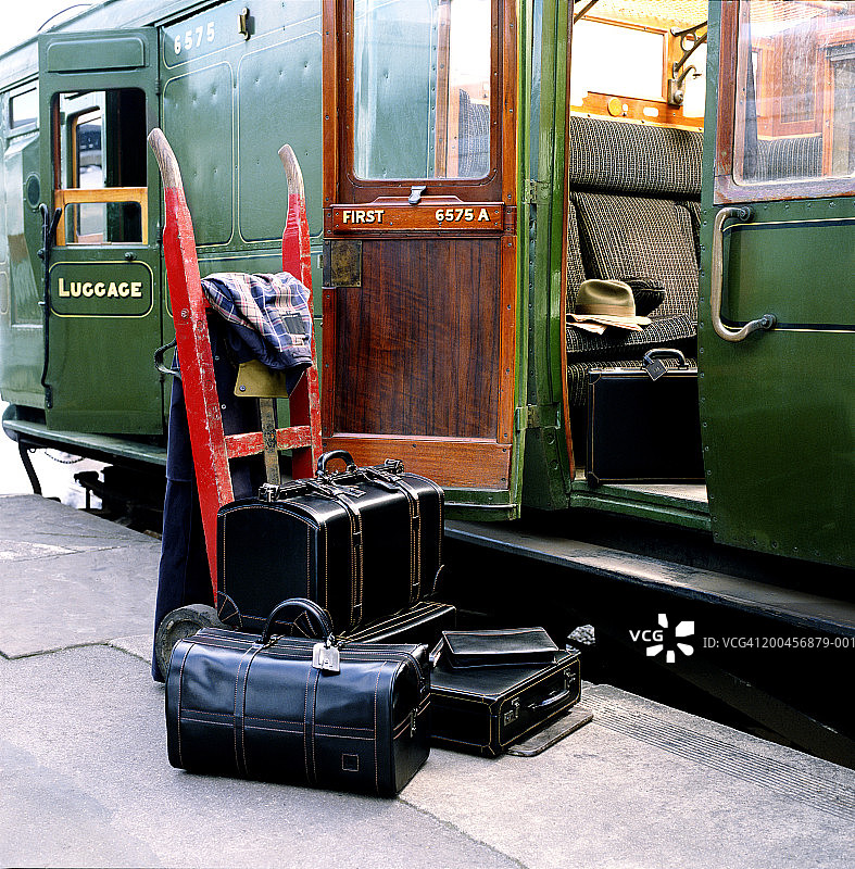 行李放在列车旁边的月台上，车厢门打开图片素材