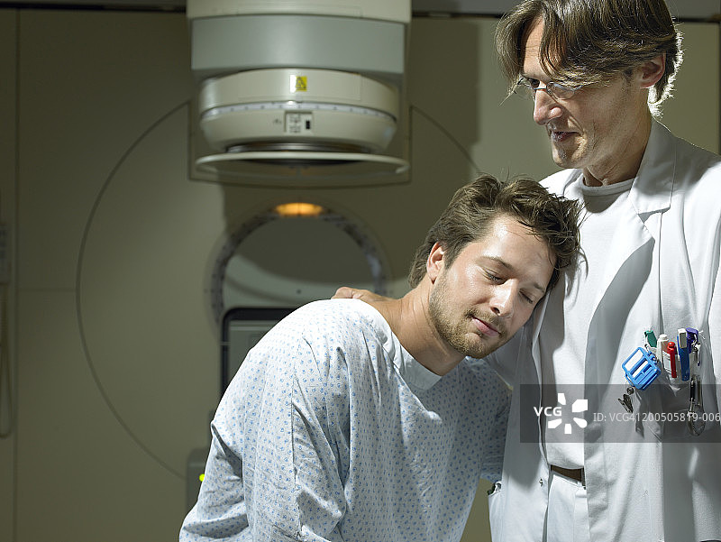 男病人在放射室靠在医生身上图片素材