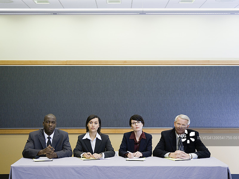 四名高管坐在桌边，肖像图片素材