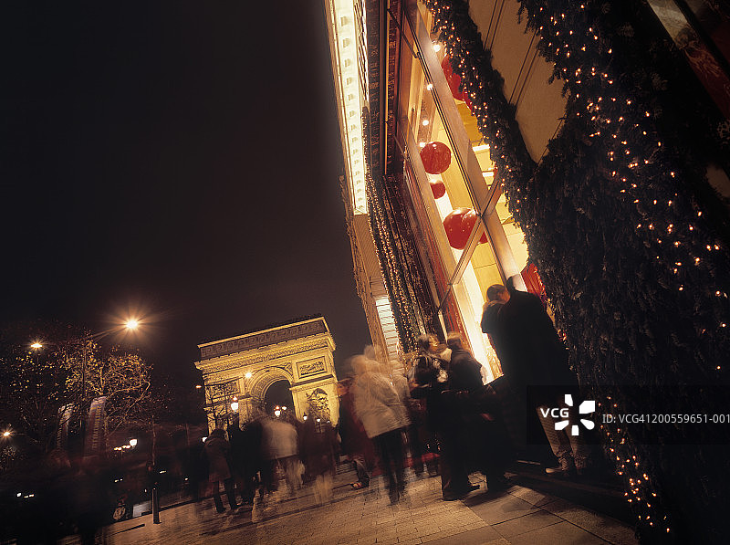 法国，巴黎，人们走着，看着圣诞橱窗陈列，夜晚图片素材