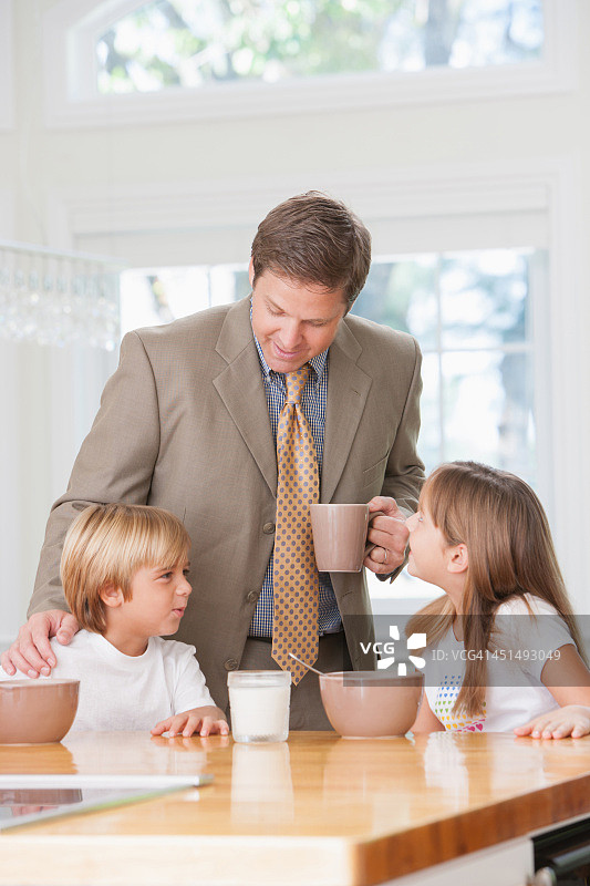 一个男人和两个小孩在厨房里聊天图片素材