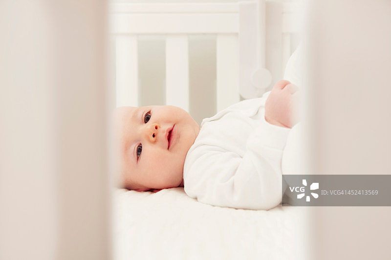 婴儿独自躺在婴儿床上图片素材