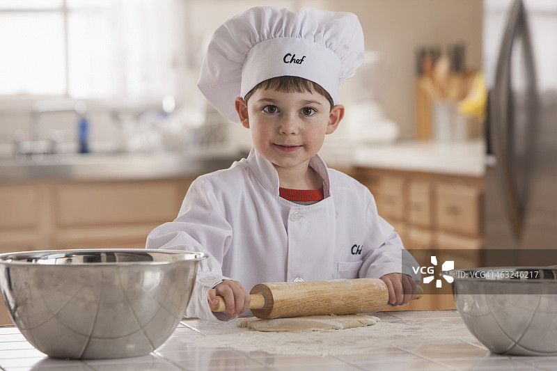 穿着厨师白衣服烤面包的男孩图片素材
