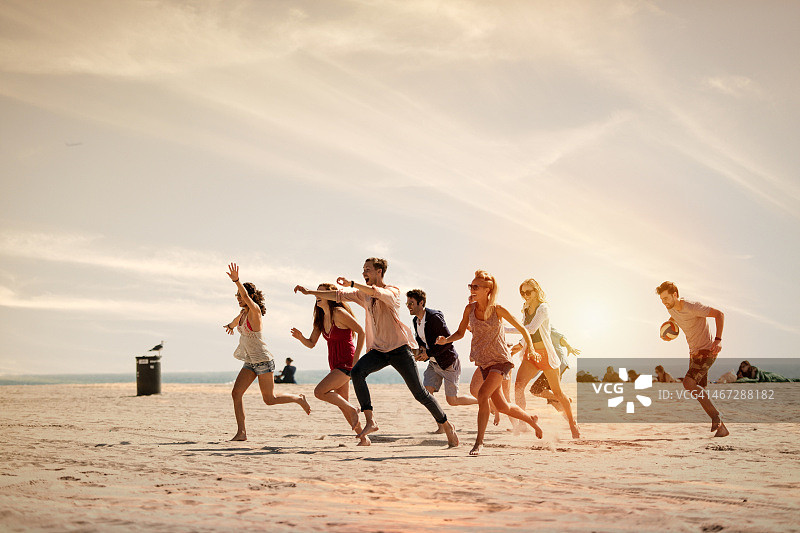 一群朋友在海滩上跑步图片素材