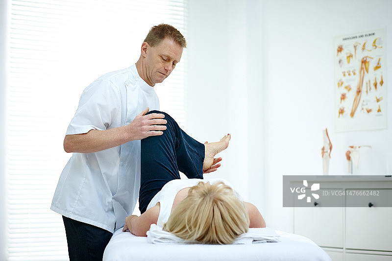 治疗女性患者膝盖的理疗师图片素材