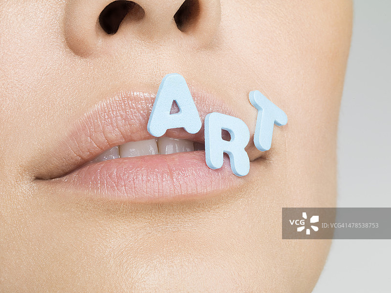 女人的嘴唇上有字母组成的单词ART图片素材