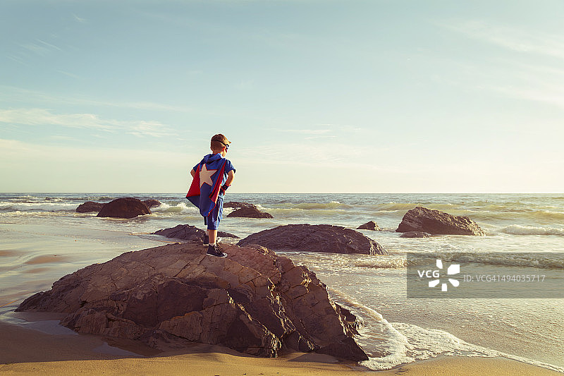 装扮成超级英雄的小男孩站在加州海滩上图片素材