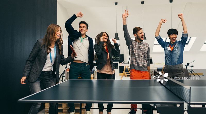 年轻人在办公室打乒乓球。图片素材