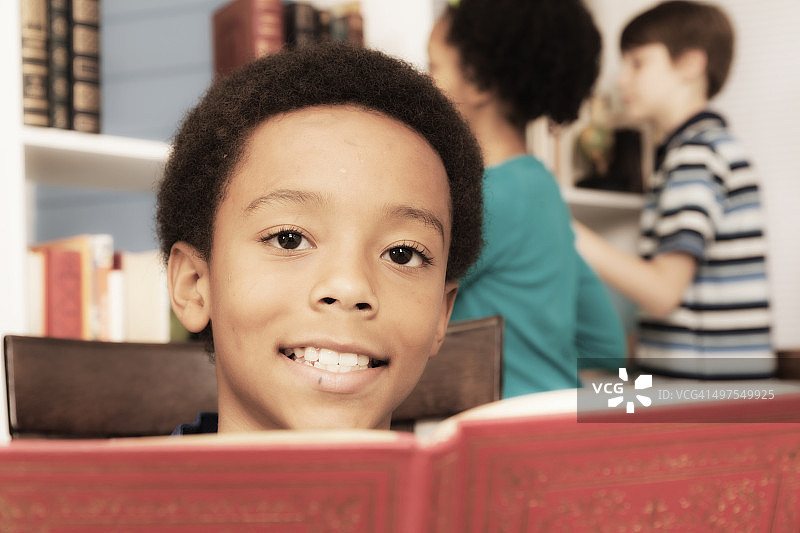 教育背景:非裔小学学生。阅读的书。图片素材