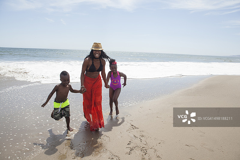 妈妈和孩子们在海滩上散步图片素材