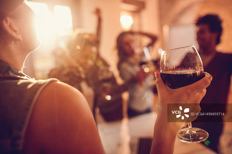 近距离的女人享受在办公室派对的葡萄酒。图片素材