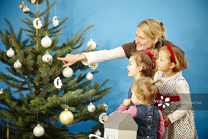 德国巴伐利亚慕尼黑，母亲和孩子们在圣诞树旁图片素材