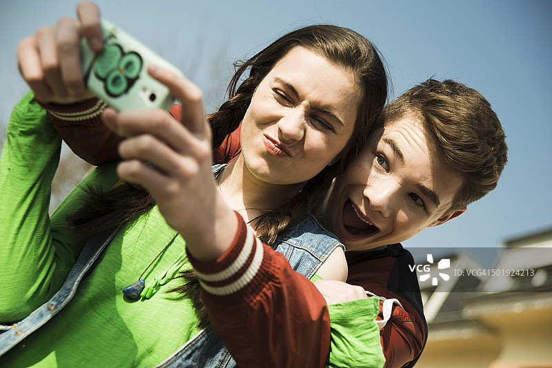 一对青少年情侣用智能手机自拍图片素材