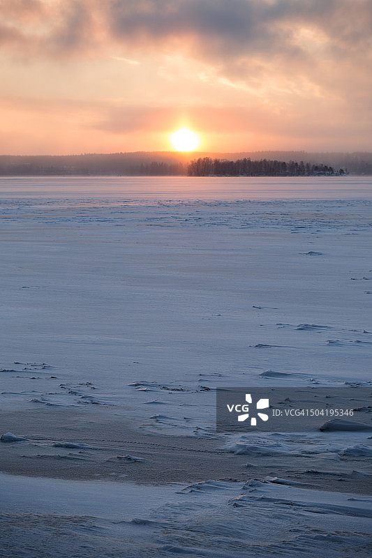 冬天，芬兰坦佩雷的冰雪湖和日出。副本的空间。图片素材