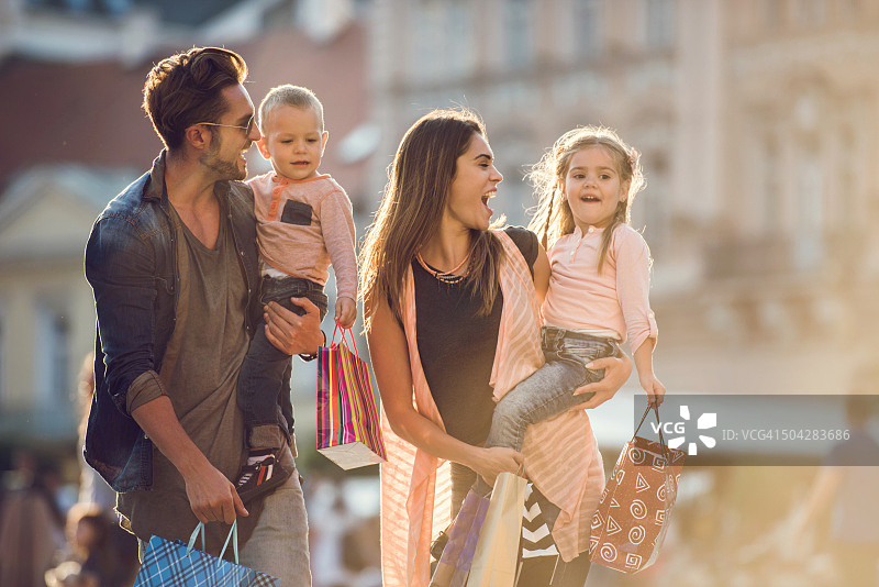 年轻快乐的家庭一起在城市购物。图片素材
