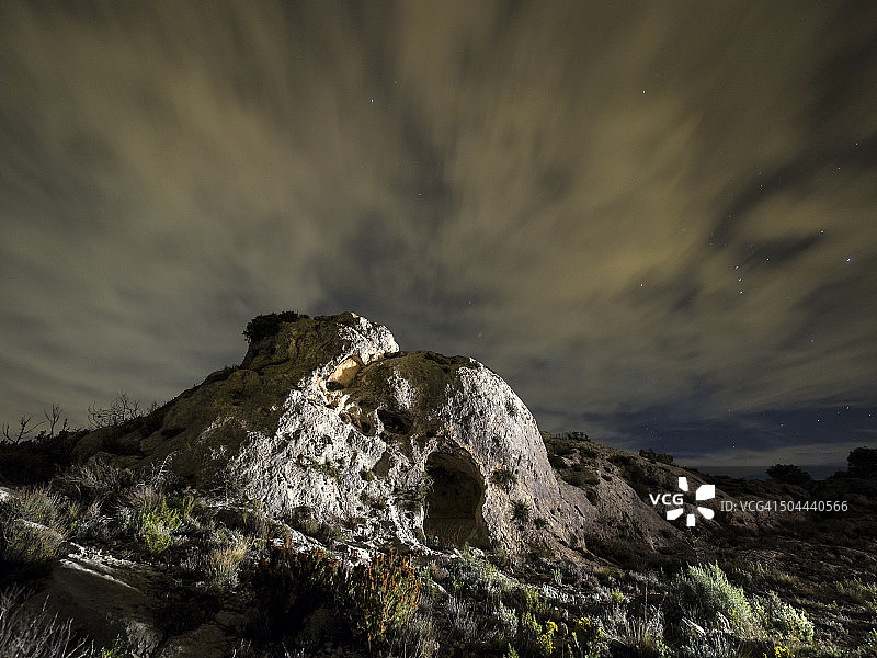 在山顶的岩石上，在夜间挖出了一个避难所图片素材