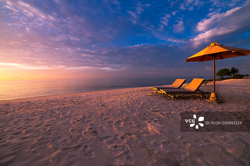 美丽的日落海滩全景日光浴床和太阳伞图片素材