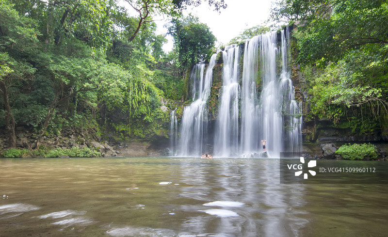 陌生的人们在哥斯达黎加的丛林里享受瀑布图片素材